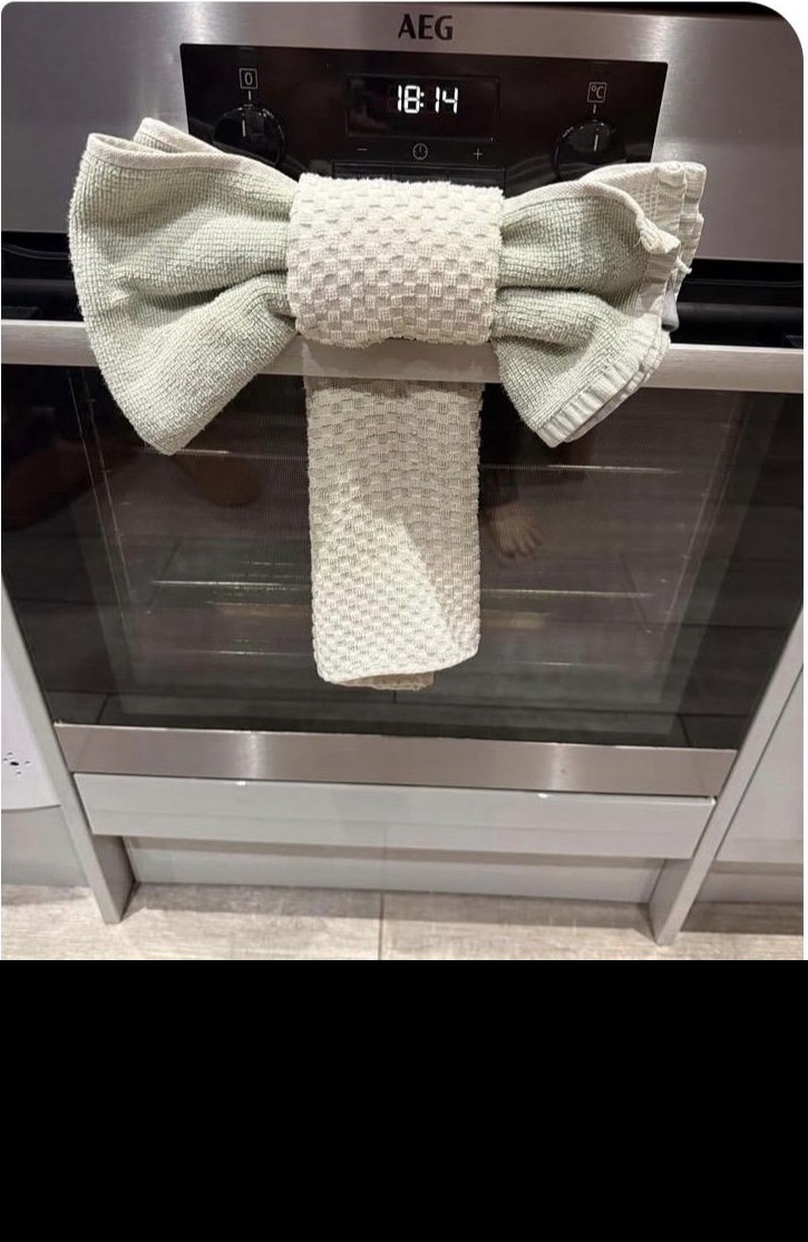 A neatly folded bow made from kitchen towels on a freshly cleaned oven
